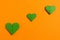 Origami hearts made with colored paper for congratulations on Valentine`s Day for couples in love, on orange background