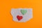 Origami hearts made with colored paper for congratulations on Valentine`s Day for couples in love, on orange background