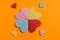 Origami hearts made with colored paper for congratulations on Valentine`s Day for couples in love, on orange background