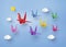 Origami made colorful paper bird flying on blue sky with clound