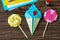 Origami paper ice cream and lollipop on a wooden table.