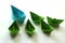 Origami paper ships in light blue and green colors.
