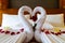 Origami swans made out of towels and laid out on a bed in a honeymoon suite