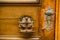 Original antique door handle-ring in gilding on a wooden door with a keyhole.