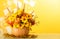Original autumn bouquet of flowers, fruits and vegetables, decorated with spikelets and spines, in pumpkin, on yellow