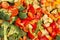 An original background of finely chopped and seasoned vegetables before baking in the oven. Potatoes, bell peppers, squash,