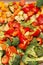 An original background of finely chopped and seasoned vegetables before baking in the oven. Potatoes, bell peppers, squash,
