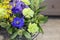 The original bouquet of blue anemones, carnations, forsythia stands in a glass vase