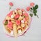Original bouquet consisting of flowers of roses, waffle cones, sweets and marshmallows on a light wooden background