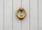 original brass knocker in the shape of a circle, grey wooden doors