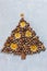 Original Christmas tree made of hazelnuts on a wooden table. Top view, close-up.