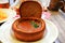 Original dish - goulash soup in bread pot, plate in restaurant, cafe. Delicious hearty meat dish of Czech, Bulgarian, Romanian