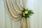 Original floral design of yellow roses and green twigs on the drapery, close-up. Floral decorations for a wedding celebration