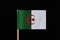 A original and official flag of Algeria on toothpick on black background. Consists of two equal vertical bars, green and white wit