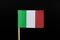 A original and official flag of Italy on toothpick on black background. A vertical tricolour of green, white and red