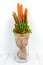 An original vegetable bouquet consisting of carrots, pea pods, lettuce leaves, red pepper and aloe is stand in a glass vase