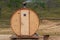 Original wooden bath in the form of a barrel. Mobile compact bathhouse on the shore of Sarai beach, Olkhon island Russia