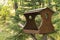 Original wooden bird feeder in the summer forest