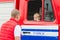 ORKI, BELARUS - JULY 25, 2018: The boy sits in a red car rescue service 112 on a holiday in the park on a summer day