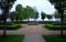 Ornamental boxwood hedge trimmed and beige threshing paths in the park round bowl or pond rainy lawns symmetrical composition