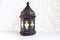 Ornamental dark Moroccan, Arabic lantern on the white table. Burning candle, glittering bokeh lights. Greeting card for