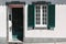 Ornamental facade of colorful house in Sao Miguel, Azores. Portugal. Beautiful old tiny houses, green doors and window