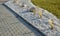 Ornamental flowerbed with perennials and gray granite boulders rocks, mulched by pebbles in urban garden, prairie, ornamental gras