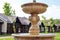 Ornamental fountain with lion heads on pedestrian street in small european city. Old town in Europe