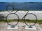 Ornamental iron bicycle under a bright sunny blue sky with white fluffy clouds