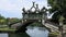 Ornamental stone bridge over water canal in royal garden. Historic building with elements of Balinese culture.