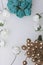 Ornaments for celebrations. Gold ring with stones and bouquet of artificial flowers. Roses are beige and emerald colors. On a whi
