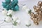 Ornaments for celebrations. Gold ring with stones and bouquet of artificial flowers. Roses are beige and emerald colors. On a whi