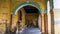 An ornate arched corridor in an ancient palace with yellow walls and vintage