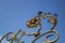 Ornate decorative elements of metal gate processing against the blue sky background