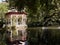 An ornate gazebo beside an ornamental duck pond.