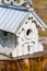 Ornate light-blue and white birdhouse on tree stump