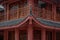 Ornate red Chinese temple with a grand entranceway featuring a painted black and red fence