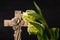Ornate religious cross with white tulip flowers on a dark background. Condolence card.
