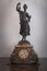 Ornate statue of woman holding decorative clock on pedestal in luxurious Venetian style