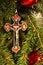 Ornate Trinitarian cross on green Christmas tree with red ornaments