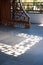 Ornate wooden screen casts interesting shadow on stone floor.