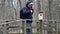 Ornithologist with binoculars and smartphone near bird cage