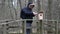 Ornithologist with binoculars and tablet PC near bird cage