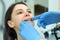 Orthodontist doctor checks the closing of the woman teeth with silicone trainer.