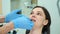 Orthodontist doctor checks the closing of the woman teeth using carbon paper.