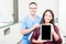 Orthodontist and patient holding tablet and smiling