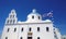 Orthodox Church Panagia in the village of Oia in Santorini with developing the flag