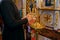 Orthodox church priest lights candles and prays, Orthodox church