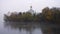 Orthodox church on a river bank at the foggy autumn day