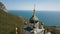 Orthodox church on a steep cliff. Sea and mountains on a background. Aerial view of Foros Church on a mountain over the